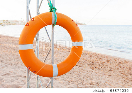 Orange lifebuoy on lifeguard tower on blue sky and 63374056