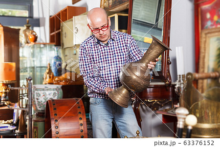 Man choosing ancient things in store 63376152