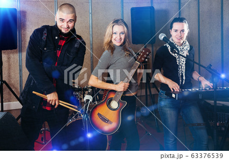 group of rock musicians posing with instruments 63376539