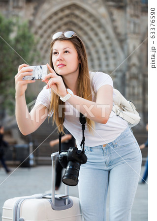 Girl holding phone and photographing 63376590