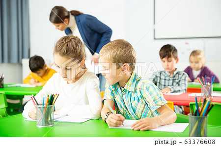 Assiduous kids studying in classroom Assiduous kids studying in classroom 63376608