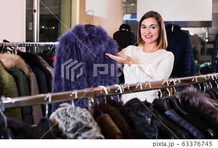 Adult woman choosing blue fur coat Adult woman choosing blue fur coat 63376745