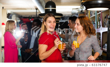 Two young women with cocktails having fun on party at nightclub 63376747