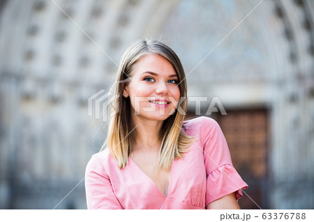 Close up of young positive female standing in the historical city center Close up of young positive female standing in the historical city center 63376788
