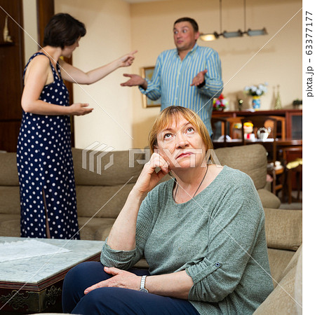 Upset elderly woman with arguing couple Upset elderly woman with arguing couple 63377177