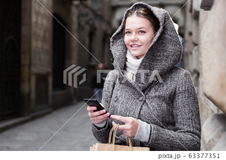 girl using mobile phone at the street 63377351