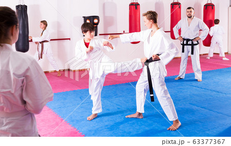 Children working in pair mastering new karate moves 63377367