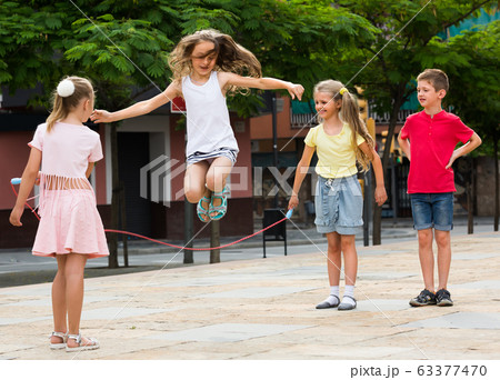 children with jumping rope at playground. children with jumping rope at playground. 63377470