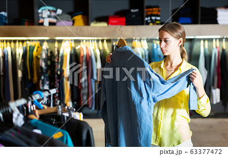 Fashionable woman buys denim shirt Fashionable woman buys denim shirt 63377472