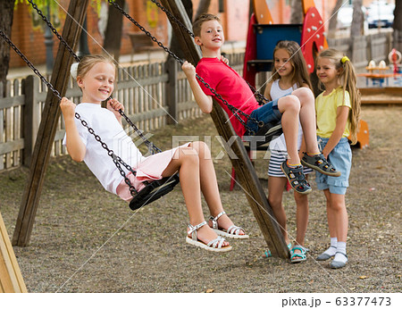 Happy friends swinging on swing 63377473