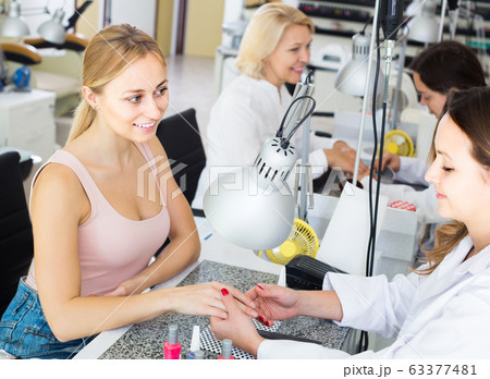 Female clients doing nails in nail salon in afternoon Female clients doing nails in nail salon in afternoon 63377481