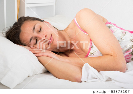 Cute woman in pygama sleeping in bed in bedroom at home interior Cute woman in pygama sleeping in bed in bedroom at home interior 63378107