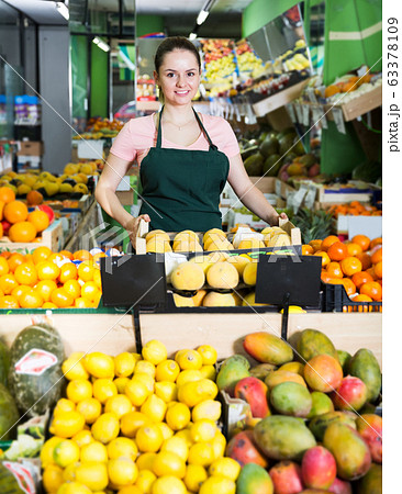 Saleswoman offering peaches in supermarket 63378109