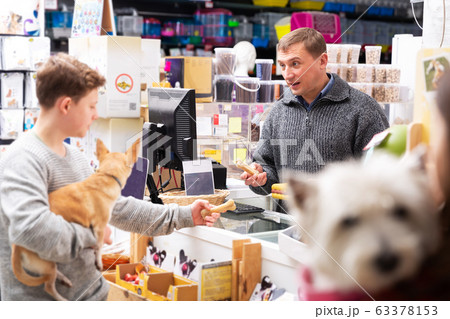 People with dogs shopping in pets shop 63378153