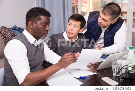 Three men are looking on documents and talking about it together Three men are looking on documents and talking about it together 63378635