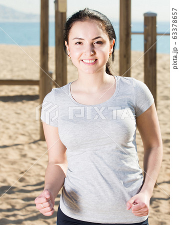 sporty girl running on beach by ocean in morning sporty girl running on beach by ocean in morning 63378657