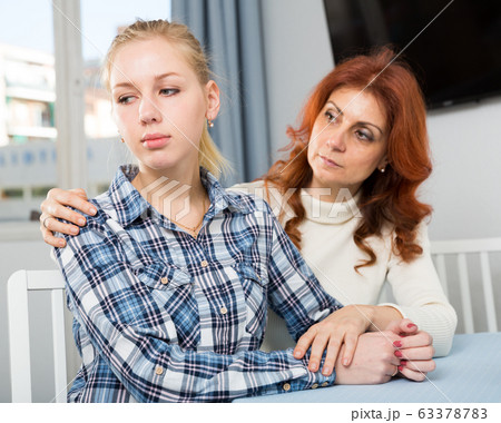 Upset mature woman talking with sad daughter at home 63378783