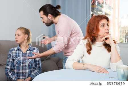 Young spouses and mother-in-low arguing indoors Young spouses and mother-in-low arguing indoors 63378959