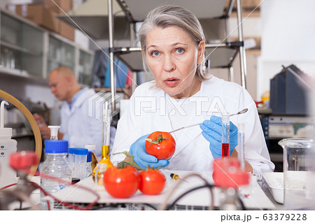 Woman biochemist checking fruits and vegetables Woman biochemist checking fruits and vegetables 63379228