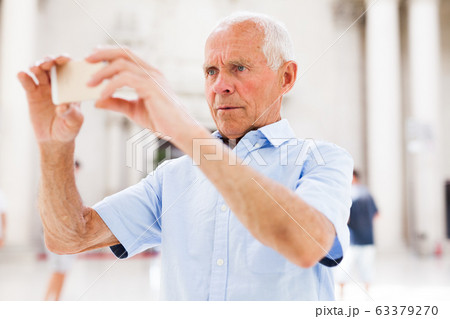 Man using smartphone in museum Man using smartphone in museum 63379270