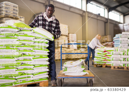 Ordinary African American man stacking bags Ordinary African American man stacking bags 63380429