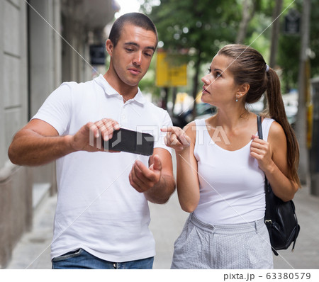 Couple using smartphone for orientation in city Couple using smartphone for orientation in city 63380579