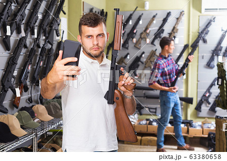 Guy taking selfie with rifle 63380658