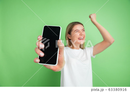 Caucasian young woman's portrait on green studio background Caucasian young woman's portrait on green studio background 63380916