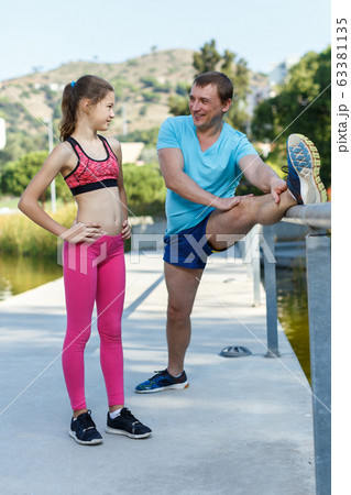 Man and tweenager girl exercising together 63381135