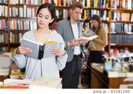 girl browsing textbooks in bookstore girl browsing textbooks in bookstore 63381200