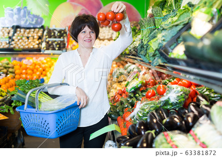 Mature woman buying fresh tomatoes Mature woman buying fresh tomatoes 63381872