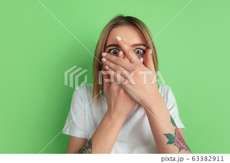 Caucasian young woman's portrait on green studio background Caucasian young woman's portrait on green studio background 63382911