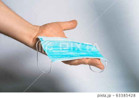 Protective face mask in hand. Surgical mask. Medical mask and corona virus protection. 63385428