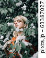Potrait. Beautiful woman among flowers, pretty girl relaxing outdoor. Close-up 63387027