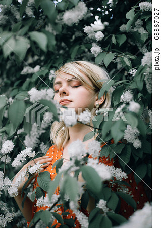 Potrait. Beautiful woman among flowers, pretty girl relaxing outdoor. Close-up 63387027