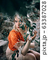 Potrait. Beautiful woman enjoying flowers, pretty girl relaxing outdoor. Close-up 63387028