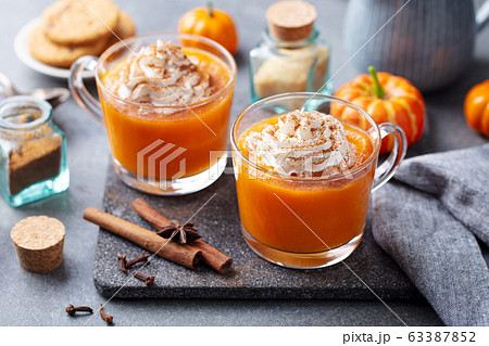 Pumpkin latte with whipped cream in glass cups. Grey background. Close up. Pumpkin latte with whipped cream in glass cups. Grey background. Close up. 63387852
