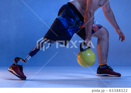 Athlete disabled amputee isolated on blue studio background Athlete disabled amputee isolated on blue studio background 63388322