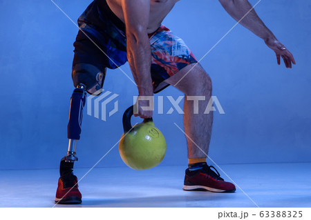 Athlete disabled amputee isolated on blue studio background Athlete disabled amputee isolated on blue studio background 63388325