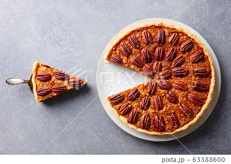Pecan nut pie, on a plate. Grey background. Close up. Top view. Pecan nut pie, on a plate. Grey background. Close up. Top view. 63388600
