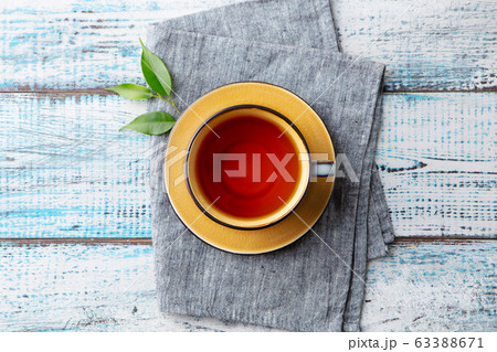 Cup of tea with green tea leaf. Blue wooden background. Top view. 63388671