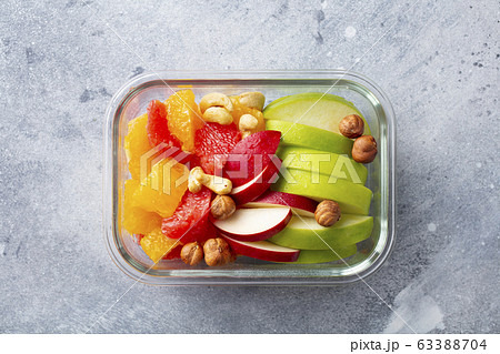 Fruits salad and nuts in a glass container. Healthy eating. Grey background. Top view. 63388704
