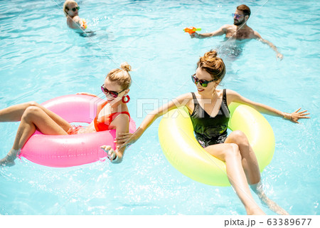 Friends playing in the swimming pool Friends playing in the swimming pool 63389677