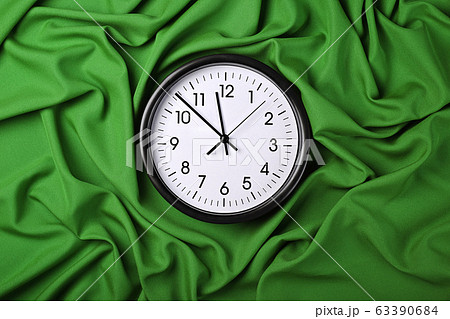 White clock over green textile folded pleats White clock over green textile folded pleats 63390684