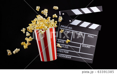Flying popcorn from striped bucket isolated on black background 63391385