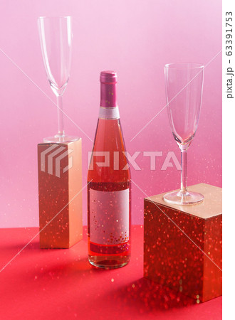 Bottle of rose wine and flutes, golden branches 63391753