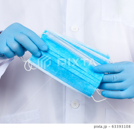 doctor in a white coat, blue latex sterile gloves doctor in a white coat, blue latex sterile gloves 63393108