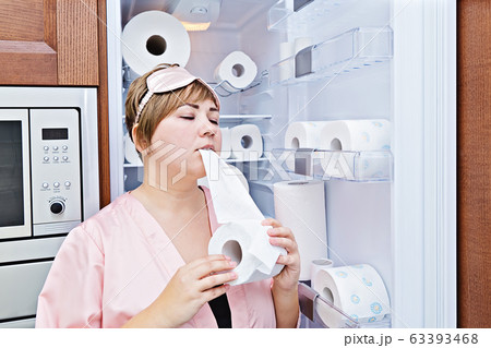 Woman in pajamas greedily eats toilet paper near Woman in pajamas greedily eats toilet paper near 63393468