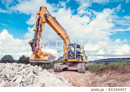 Woman construction worker with excavator on site 63394407