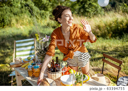 Woman preparing for the festive dinner outdoors Woman preparing for the festive dinner outdoors 63394755